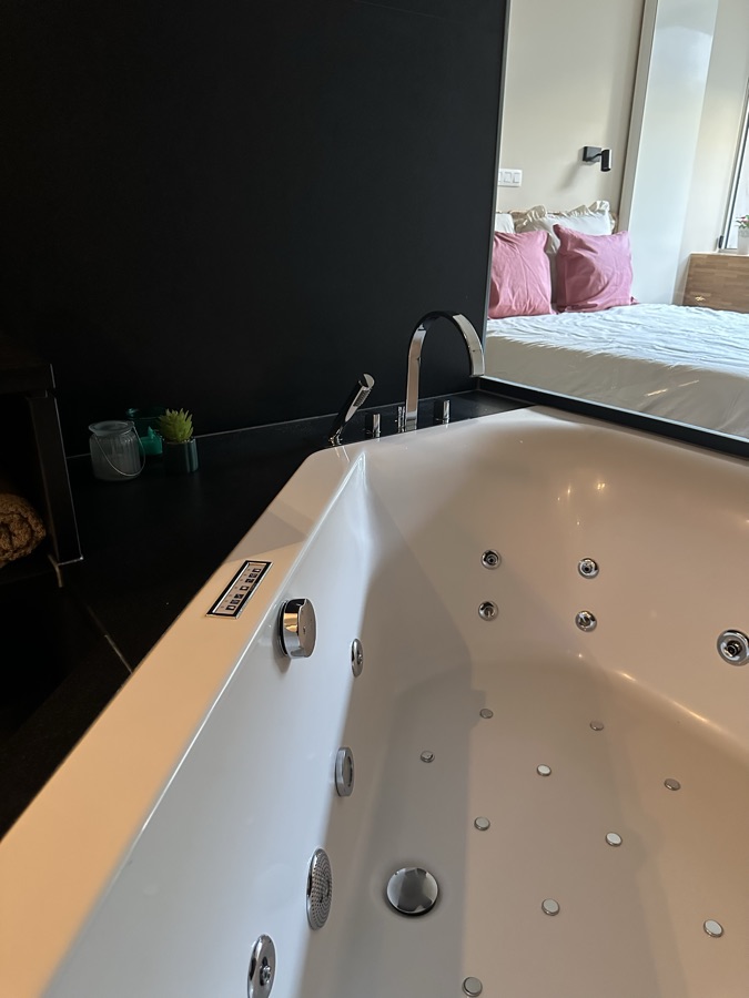 Whirlpool bath with a view of the adjoining bedroom