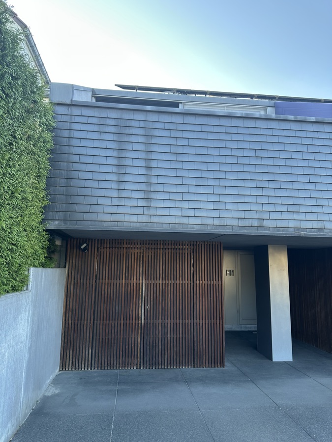 Wooden gate of the covered bike shed beneath the house