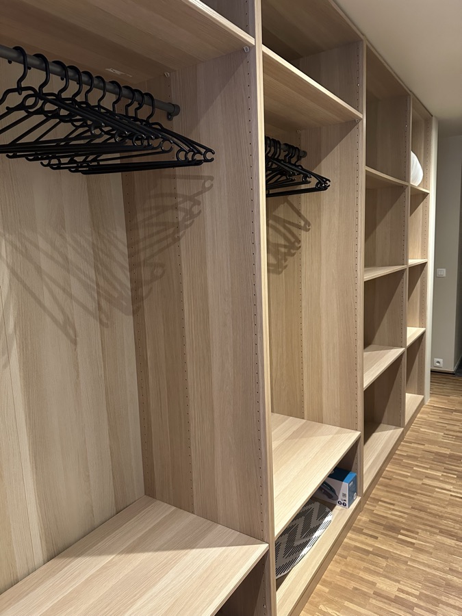 Open oak wardrobe compartments with coat hangers