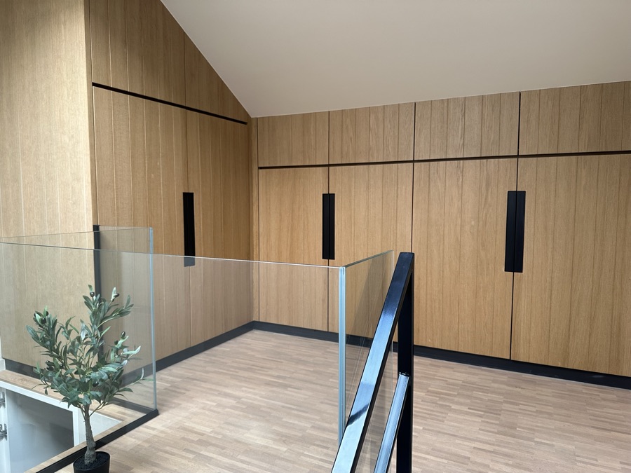 Landing with oak cupboards and a glass balustrade