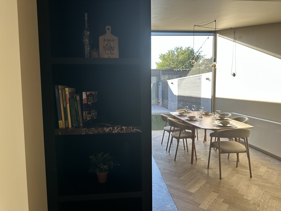 Black bookcase with a view through to the dining table and the terrace